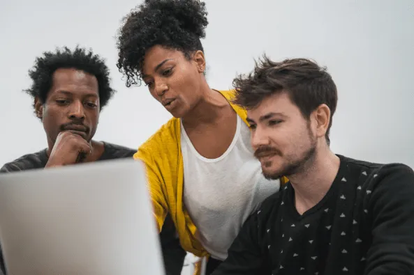 Woman showing something to colleagues on laptop